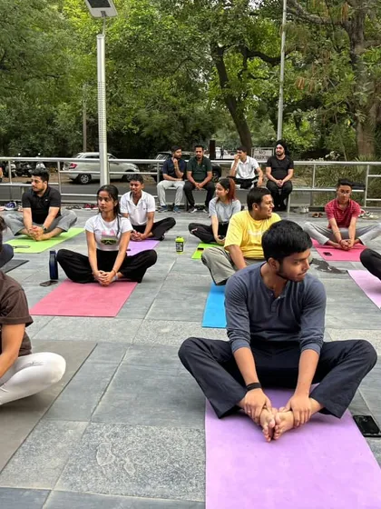 Participants practice a seated hip-opening pose during our Chandigarh community event. We offer modifications and guidance to ensure everyone can participate comfortably.