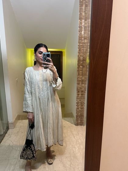 A mirror selfie in a beautiful off-white Anarkali. The intricate chikankari work makes it a timeless piece for any festive wardrobe.