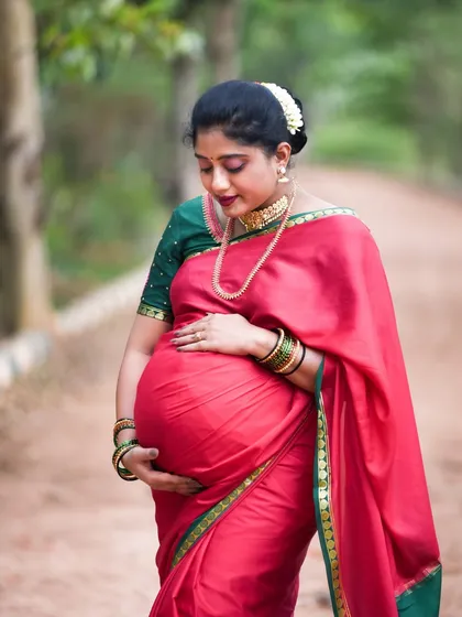 Embracing tradition is always beautiful. For this outdoor session, the mom-to-be wore a gorgeous red and green silk saree, creating a timeless and culturally rich portrait that celebrates her heritage.