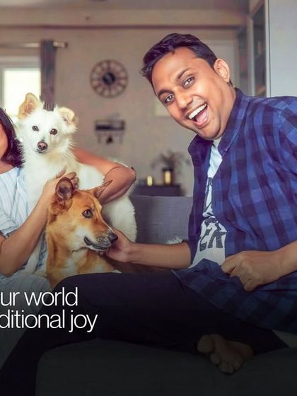A moment of pure, chaotic joy with a couple and their two dogs. This photo perfectly captures the fun and energy of a multi-pet household.