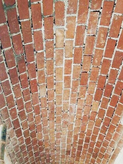 A detailed shot looking directly up at the intricate pattern of the brick vault while it's still supported by scaffolding. It's a beautiful example of structural art.