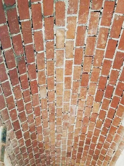 A detailed shot looking directly up at the intricate pattern of the brick vault while it's still supported by scaffolding. It's a beautiful example of structural art.