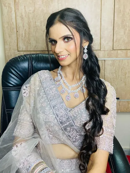 A beautiful smiling portrait of the client, showcasing her complete engagement look with jewelry and styled hair.
