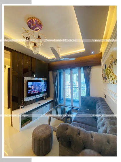 A wider view of the living room in Majestic Villa, showing the relationship between the seating area, the TV unit, and the entrance to the kitchen. The layout is designed for easy movement and a spacious feel.