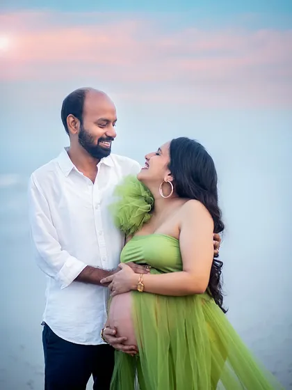 A close-up capturing the happy and loving expressions of the parents-to-be during their beach maternity shoot.