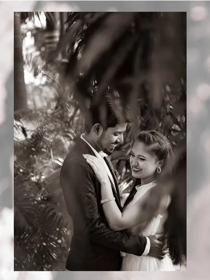 A romantic black and white photo of a couple framed by lush greenery. I often use natural elements to create depth and a sense of intimacy in my pre-wedding photography.