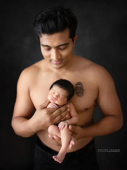 A father's love, forever inked on his chest. This portrait shows a new dad holding his baby girl, his tattoo a permanent symbol of his love.