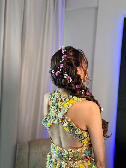 Another angle of the floral side braid, highlighting its texture and volume. This is a stunning look for any pre-wedding celebration.