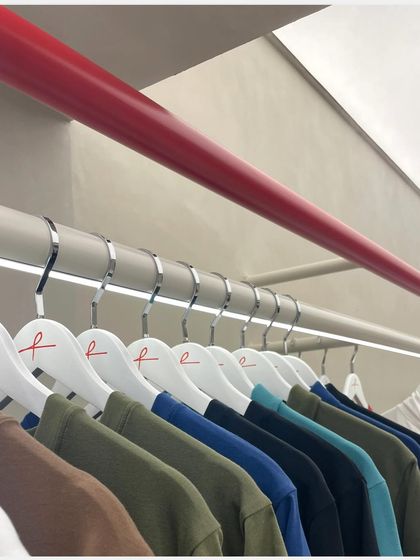 A row of colorful apparel on display, showing how the neutral store design allows the products to provide the primary color story.
