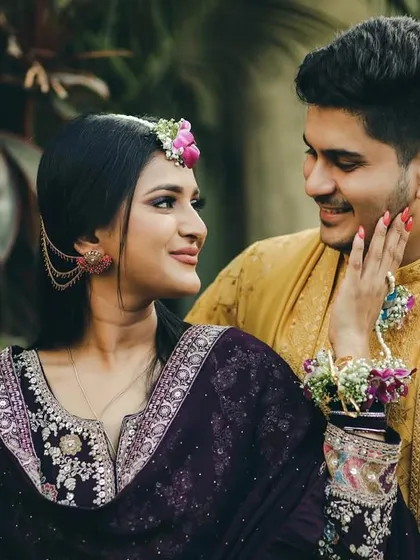 A sweet and playful moment from a pre-wedding event. The bride gently touches the groom's cheek, and their loving gaze speaks volumes.