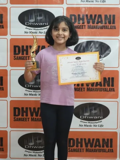 A happy student from our kids' art class with her first trophy. We aim to make learning art a rewarding and joyful experience from a young age.