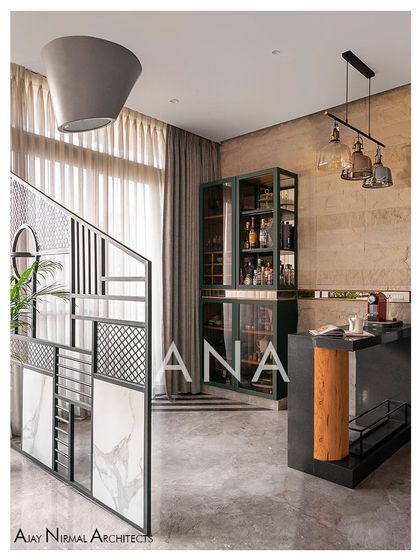 A custom-designed metal partition separates the bar from the sitting area in Apartment 704. The bar itself features rough stone cladding and a modern cabinet, with an inverted conical hanging light elevating the composition.