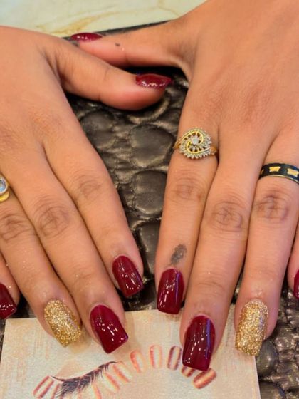 A classic combination of deep red and gold glitter on square nails. This festive look is perfect for weddings, parties, or any celebration.