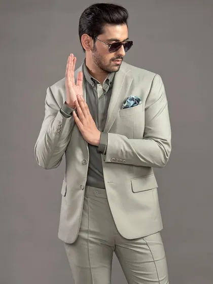 The same sage green suit styled with a tonal green shirt and a patterned pocket square. This demonstrates the versatility of a bespoke suit for different levels of formality.
