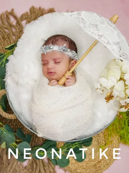 An angelic portrait of a newborn sleeping under a delicate lace umbrella. This setup is all about softness and serenity.