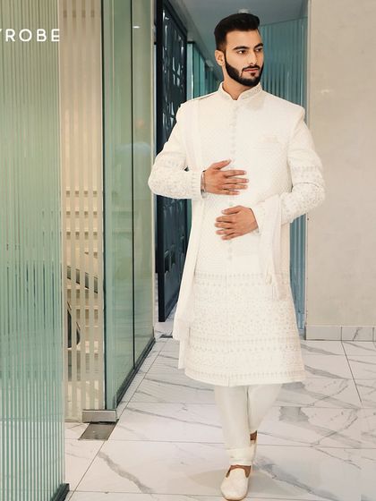 A clean and crisp all-white sherwani with delicate embroidery. This outfit is perfect for grooms who prefer an understated yet elegant look for their wedding day.