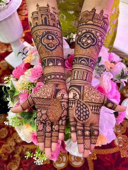 This design features bold peacock motifs on the palms, set against a background of delicate flowers. The arms showcase architectural patterns inspired by Rajasthani palaces.