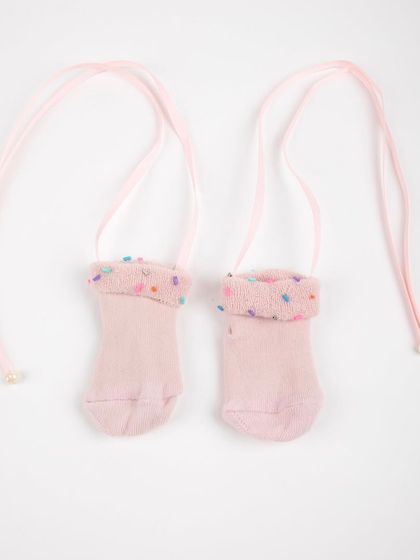 A product shot of the adorable pink baby socks with tie-strings.