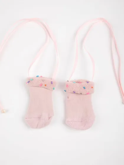A product shot of the adorable pink baby socks with tie-strings.