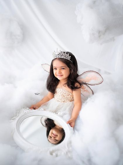 This little angel is admiring her reflection in a magic mirror.