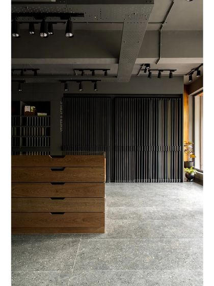 The main showroom floor, with its clean lines, industrial-style track lighting, and focus on the material displays.