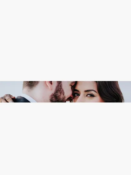 A creative, minimalist composition focusing on the bride's expressive eyes as the groom whispers to her. This shot is intimate and intriguing, telling a story with just a glance.