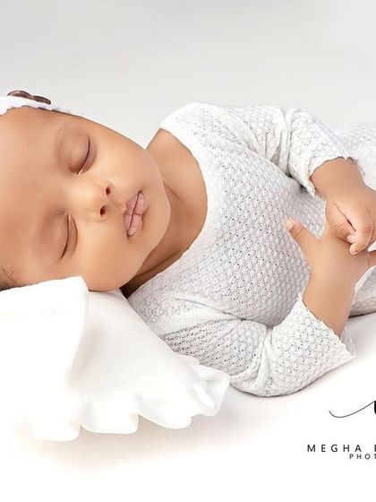 A full-body shot of the baby stretching out in his sleep, looking completely comfortable.