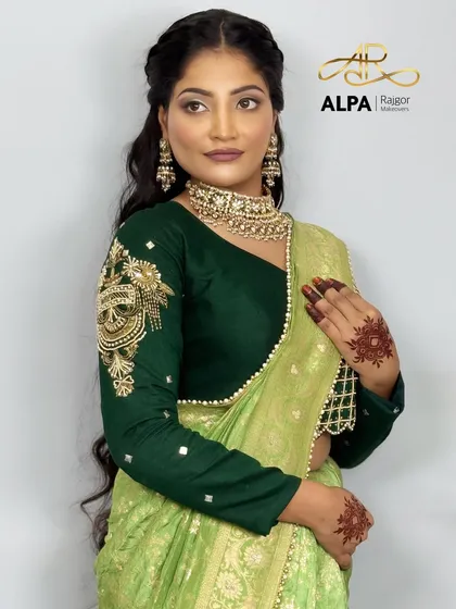 A soft and romantic hairstyle for long hair, paired with a beautiful green saree. The makeup is kept subtle and glowing.