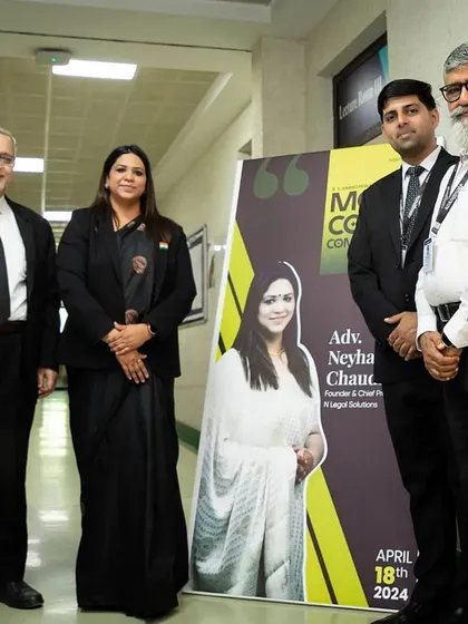 Standing with fellow judges next to a banner featuring my profile for the moot court competition. It is humbling to be featured as a guest and expert in these academic events.