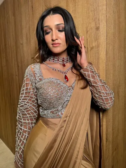 The rich texture of the satin and the intricate blouse are the stars here. The draping is kept simple and elegant to complement them.