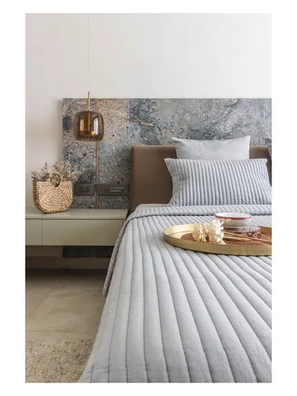 The texture and color variation in the marble headboard make it a true piece of art, anchoring the entire room.