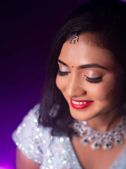 A close-up of Rakshita's reception makeup. The look features a bright red lip and shimmering silver eyeshadow, perfect for an evening celebration.