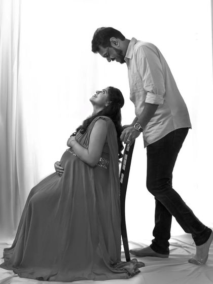 A black and white maternity portrait with soft, high-key lighting. This creates a gentle and timeless image, focusing on the couple's quiet connection.
