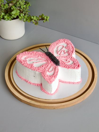 When a little girl has her heart set on a butterfly, you bring that vision to life. This butterfly-shaped cake is a great example of my "minimal cream, maximum flavor" style, focusing on a beautiful shape and delicate piping work.