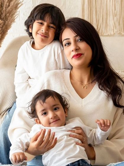 A mother with her two children in a warm, boho-style studio setting. I am experienced in photographing families with children of different ages together.