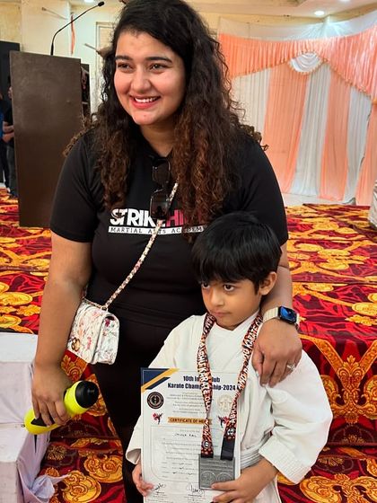Our founder, Lipika, poses with a young champion at a karate competition. We are there to support our students every step of the way.