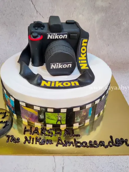 A cake for a true Nikon ambassador. I sculpted this realistic camera cake entirely from fondant, paying close attention to the details of the lens, buttons, and brand logos. The edible film strip around the base features the photographer's own pictures.