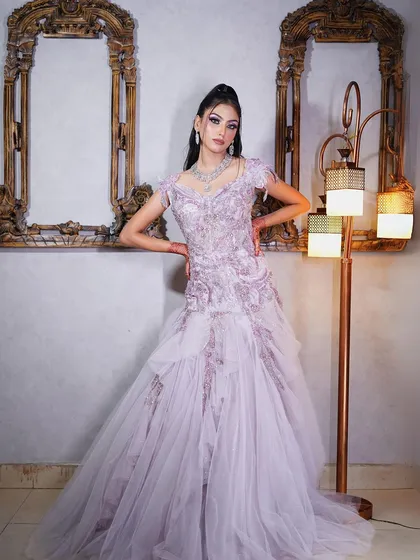 A full-length shot showing the delicate layers and embroidery of the lilac gown.
