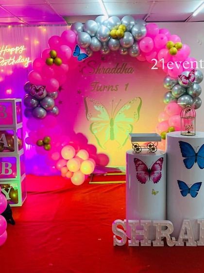 A stunning butterfly theme with a pink and purple color scheme. The neon lighting and chrome balloons create a modern, magical glow.