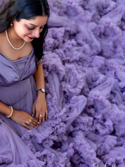 A beautiful overhead shot focusing on the incredible texture of the lavender ruffled gown. The sheer volume of the train creates a soft, dreamy bed of fabric.