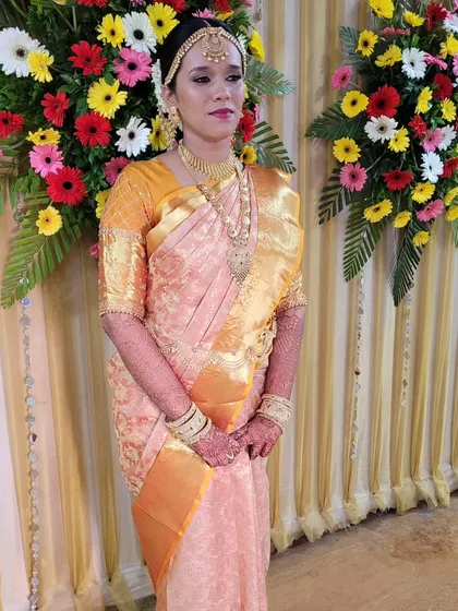 A Marathi mulgi, Nikita, beautifully draped in a Pink and Yellow Kanjeevaram for her Malayali wedding rituals, blending traditions with grace.