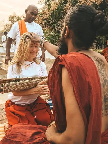 A student receives a traditional blessing during a ceremony. This is a moment of initiation and deep connection, marking a significant step on her spiritual path.