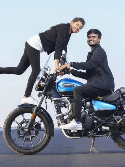 A fun and adventurous pose on a blue motorcycle. This is a great shot for couples who love to ride.