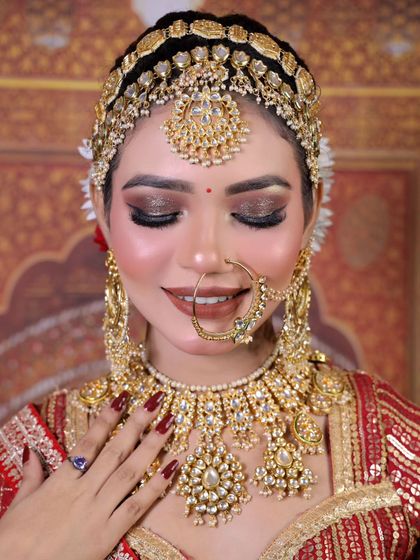 A stunning close-up of a bride wearing a full golden Polki set, including a choker, hathphool, and an intricate matha patti.