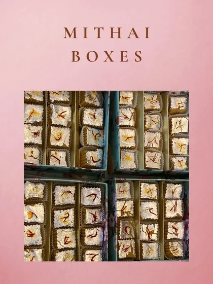 A top-down view of our mithai boxes, filled with freshly made sweets and garnished with saffron. These are perfect for bulk orders and corporate gifting.