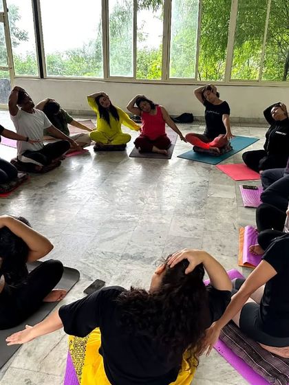 The vibrant energy of our yoga retreat in Rishikesh. We gather in a circle for neck stretches, creating a sense of unity and shared purpose.