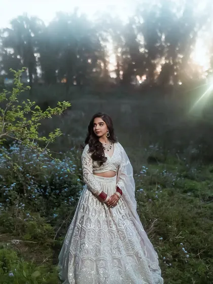 This outdoor shot with the sun flare is magical. Her reception makeup looks stunning in the fading light.