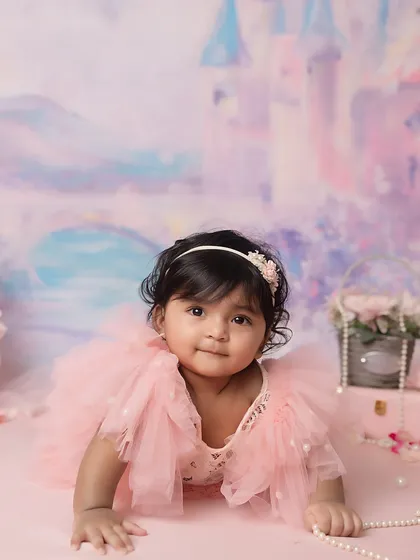 This little princess looks directly at the camera, her personality shining through. I use props like pearls and flowers to add detail to themed shoots.