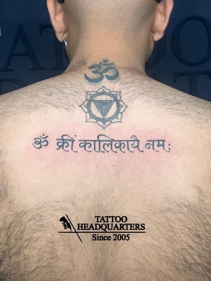 A spiritual backpiece featuring the mantra "Om Kreem Kalikayai Namah" below a Vishuddha (throat) chakra symbol and an Om at the nape of the neck.