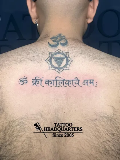 A spiritual backpiece featuring the mantra "Om Kreem Kalikayai Namah" below a Vishuddha (throat) chakra symbol and an Om at the nape of the neck.